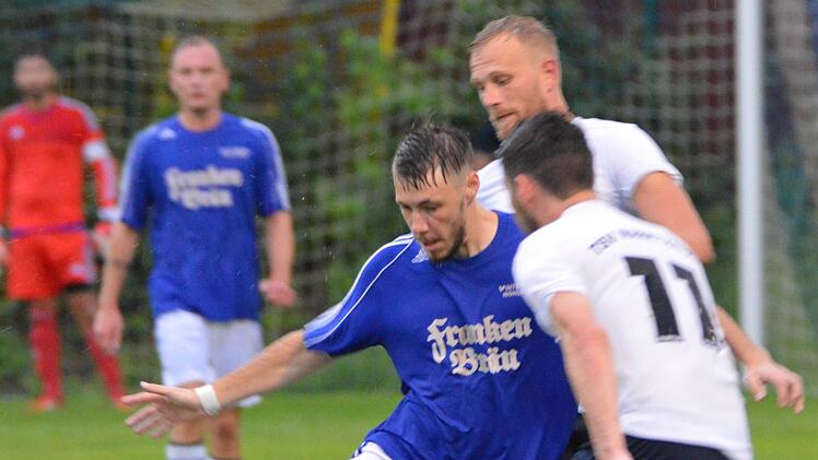 FC Mitwitz II - TSV Marktzeuln: Gegen zwei Gästespieler versucht der Mitwitzer Max Schülein (blaues Trikot) sein Glück, bleibt aber hängen. Foto: Gunther Czepera