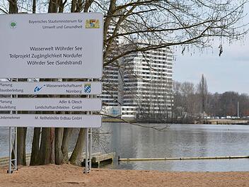 Ein Schild der Wasserwelt Wöhrder See mit dem Sandstrand. Im Hintergrund ist das Südufer zu sehen. Foto: Nikolas Pelke