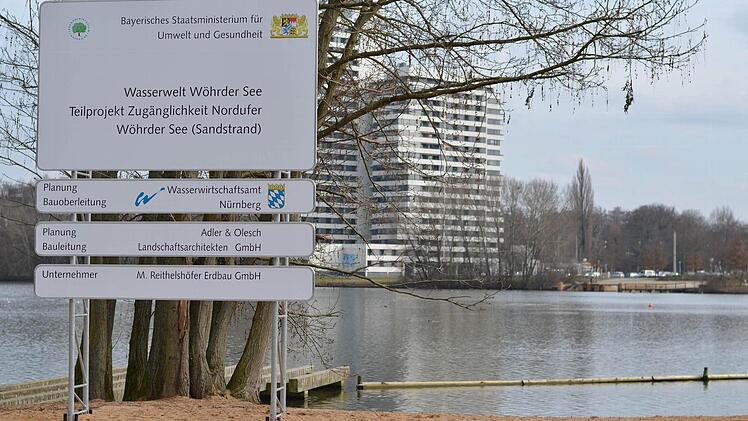 Ein Schild der Wasserwelt Wöhrder See mit dem Sandstrand. Im Hintergrund ist das Südufer zu sehen. Foto: Nikolas Pelke
