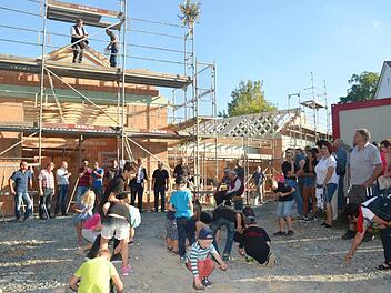 Zimmerermeister Hans-Jürgen Stübinger, Ortssprecher Volker Wündisch (beide auf dem Gerüst), am Feuerwehrhaus unten Bürgermeister Bernd Rebhan (Dritter von rechts) mit Vertretern der Dorfgemeinschaft und von bauausführenden Firmen beim Richtfest Karl-Heinz Hofmann