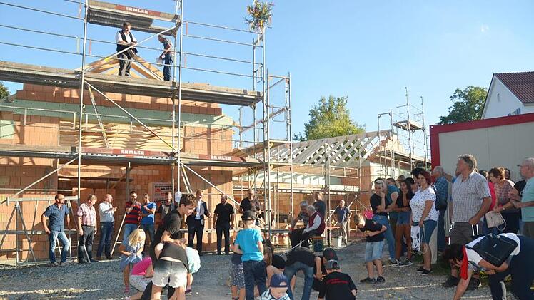 Zimmerermeister Hans-Jürgen Stübinger, Ortssprecher Volker Wündisch (beide auf dem Gerüst), am Feuerwehrhaus unten Bürgermeister Bernd Rebhan (Dritter von rechts) mit Vertretern der Dorfgemeinschaft und von bauausführenden Firmen beim Richtfest Karl-Heinz Hofmann