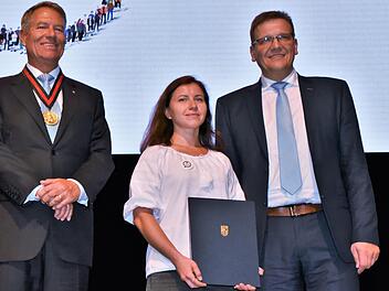 Neben dem rumänischen Staatspräsidenten und Karlspreisträger Klaus Johannis (links) und Heiligenhof-Direktor und stellvertretenden Bundesvorsitzenden der Sudetendeutschen Landsmannschaft, Steffen Hörtler, nahm Olga Kovalchuk stellvertretend für de...