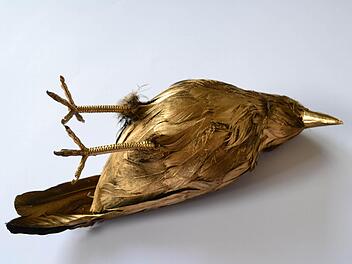 Eine golden Krähe symbolisiert den Respekt vor dem Tod.