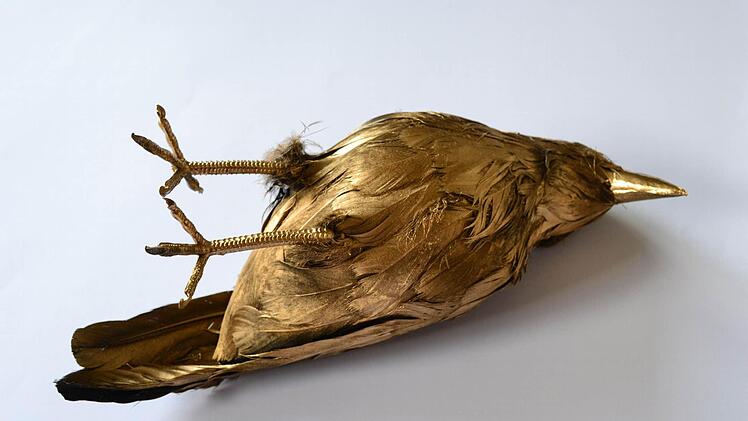 Eine golden Krähe symbolisiert den Respekt vor dem Tod.