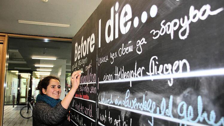Maria hat den Kubus des Kunstprojekts "Before I Die" im Uni-Gebäude am Bamberger Markusplatz entdeckt und gleich einen ihrer Wünsche hinterlassen. Mit Kreide können Besucher hier aufschreiben, was sie noch machen wollen, bevor sie sterben.  Foto: Sebastian Martin