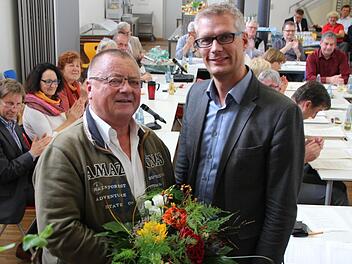 Heinz Endres bekommt von Oberbürgermeister Uwe Kirschstein Blumen überreicht. Foto: Jennifer Hauser