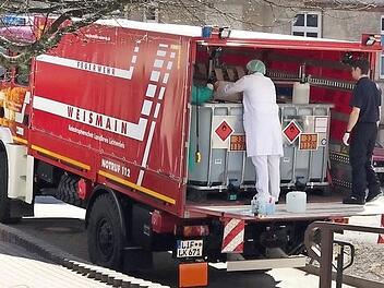 Zwei Aktive der Freiwilligen Feuerwehr Weismain beim Transport des reinen Alkohols zur Verarbeitungs- und Ausgabestelle Foto: Freiwillige Feuerwehr Weismain
