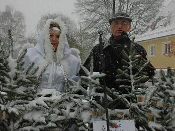 Bürgermeister Wilhelm Schneider mit dem Christkind Desiree Büschel hinter Tannenspitzen. Fotos: Gerhard Schmidt