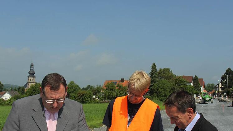 Siegfried Beck vom Bauamt, Jörg Döhler von der Baufirma Rädlinger und Bürgermeister Norbert Gräbner (von links) an der Baustelle bei Seibelsdorf. Im Hintergrund wird am neuen Gehweg gearbeitet.