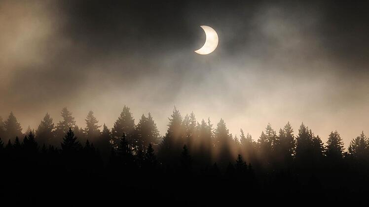 Sichelförmig erscheint die Sonne am 04.01.2011 am Stadtrand von Freiburg über dem Schwarzwald. Der dunkle Neumond schiebt sich vor die Sonnenscheibe und verdeckt bis zu drei Viertel von ihr. Foto: Hugo Waschkowski/dpa