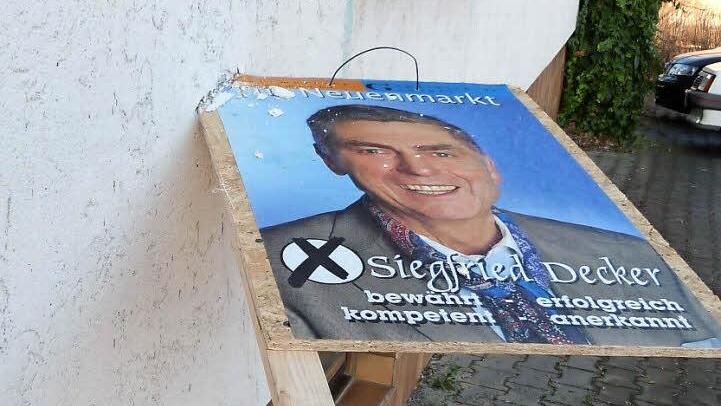 In Neuenmarkt wurde ein Werbeständer der Neuenmarkter Gemeinschaft, auf der Bürgermeisterkandidat Siegfried Decker abgebildet ist, in eine Hausfassade gerammt. Foto: Werner Reißaus