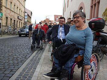 Norbert Knobel (VdK Untererthal) und Bürgermeister Armin Warmuth testen einmal selbst das Pflaster rund um das Rathaus. Maria Nürnberger, die seit ihrer Geburt auf einen Rollstuhl angewiesen ist, führt sie an. Foto: Arkadius Guzy