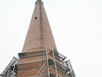 Der alte Schornstein auf dem ehemaligen Spinnereigelände wird in den kommenden Wochen saniert. Gestern begannen die Gerüstarbeiten. Foto: Sonja Adam