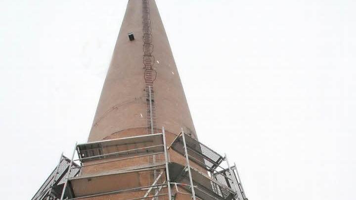 Der alte Schornstein auf dem ehemaligen Spinnereigelände wird in den kommenden Wochen saniert. Gestern begannen die Gerüstarbeiten. Foto: Sonja Adam
