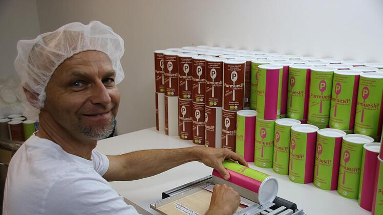 Die Verpackungsdosen hat er bisher selbst mit dem "Purmuesli"-Logo beklebt.