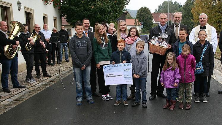 Bei der Einweihung des neu gestalteten Ortskern von Windischgaillenreuth gab es Musik und noch einen Scheck. TG-Vorsitzender Siegfried Lange, Pfarrer Herbert Hautmann, Bürgermeister Franz Josef Kraus und Ortssprecher Stefan Kormann (v.re.) freuen sich über den von Filialleiter Ingo Richter (li.) überreichten Spendenscheck von 1000 Euro für den Kinderspielplatz. Fotos: fra-press