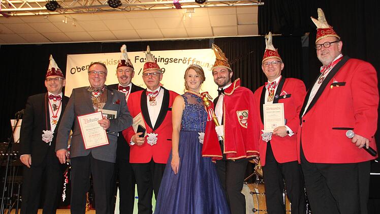 Der Fastnachtsverband Franken ehrte verdiente Fousanaochter. Das Bild zeigt (von links): Gernot Sch&ouml;pf vom Ordenskapitel Oberfranken, Wolfgang "N&ouml;lla" Baumann, Bezirkspr&auml;sident f&uuml;r Oberfranken, Norbert Greger, Sitzungspr&auml;sident Georg L&ouml;ffler, das Prinzenpaar Karolin I. und Basti I., Vizepr&auml;sident Andreas Bauer und Pr&auml;sident Uli B&ouml;hm. Foto: Friedwald Schedel