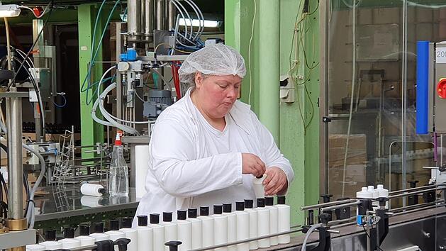 Diese Mitarbeiterin f&uuml;llt Flaschen ab und ist froh, trotz Corona-Krise erst einmal ihren Arbeitsplatz behalten zu k&ouml;nnen. Foto: Maria L&ouml;ffler