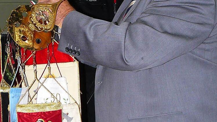 Gabor Penzes heftet ein Fahnenband an die Standarte der Feuerwehr Marktleugast.