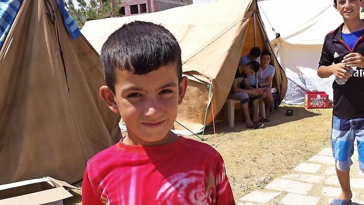 In Sicherheit: Der Junge im Flüchtlingslager in Erbil kann schon wieder ein wenig lächeln. Fotos: Joost Butenop/Malteser International