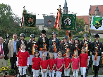 Standarten der Reitvereine beleben das Bild der Kreismeister im Reiten 2014 vor der Klosterkirche Sonnefeld. Mit im Bild der RSG-Nachwuchs sowie Peter Lehnert und Michael Keilich (links), Friedhold Riß und Landrat Michael Busch (rechts). Foto: Klaus Oelzner