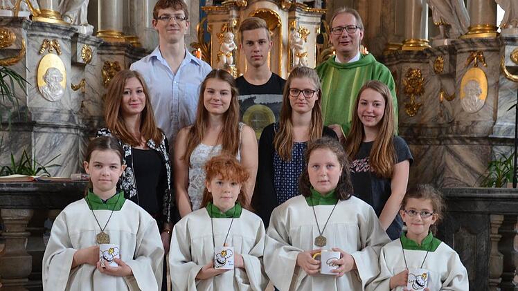 Neue und verabschiedete Ministranten: Unser Bild zeigt Pfarrer Thomas Eschenbacher (hinten, rechts) mit den Neuen (vorne, von links) Hanna Schroer, Christina Weiß, Selina Schmittroth und Luisa Feser sowie den Verabschiedeten (zweite Reihe, von links) Viktoria Pfeuffer, Franziska Marx, Anna-Lena Oswald und Anna Heger sowie (hintere Reihe, von links) Samuel Ziegler sowie Christopher Schmähling.  Foto: Jana Keul