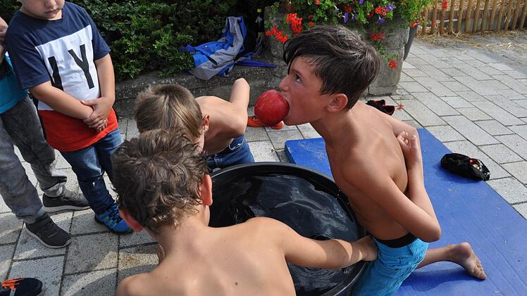Auch am Wassertrog herrschte beim Apfelwettschnappen stets Hochbetrieb und der eine oder andere tauchte nicht nur mit dem Apfel  sondern auch mit klitschnassen Haaren und Klamotten aus dem Wasser wieder  auf.