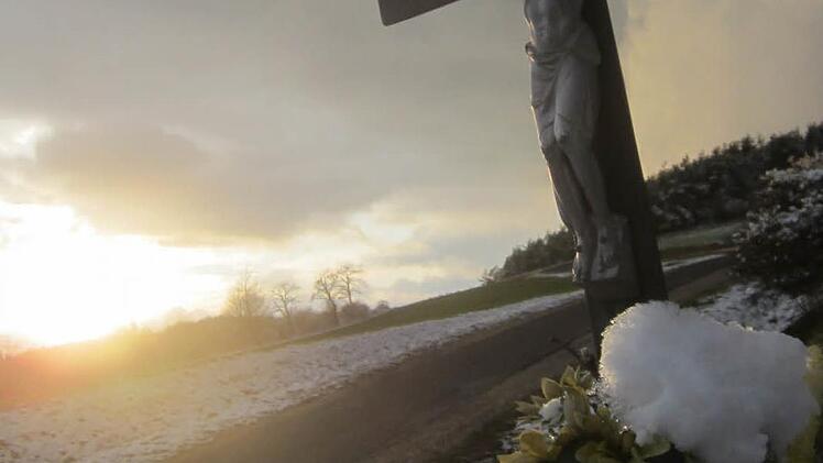 Eine Wolkenfront zieht über der Jura-Hochfläche heran - hier ein Feldkreuz bei Dörrnwasserlos. Foto: Matthias Einwag