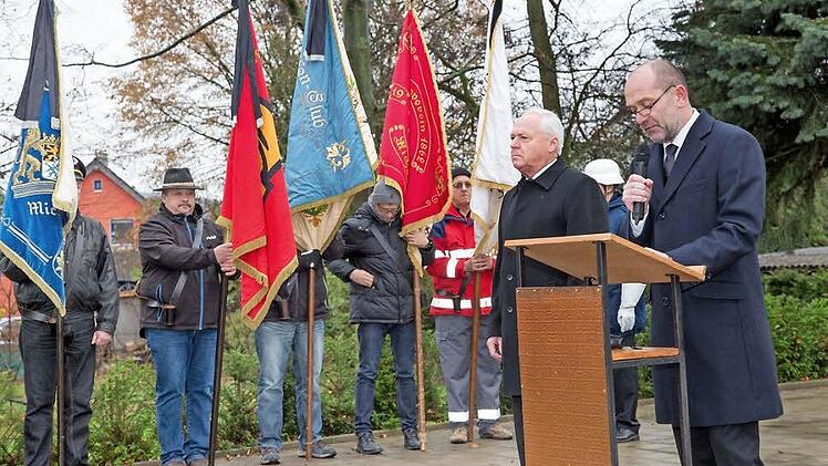 Bürgermeister Helmut Fischer und Dekan Johannes Grünwald riefen zum Gedenken an die Toten der beiden Weltkriege auf. Im Hintergrund die Fahnenabordnungen der Michelauer Vereine.  Foto: Klaus Gagel