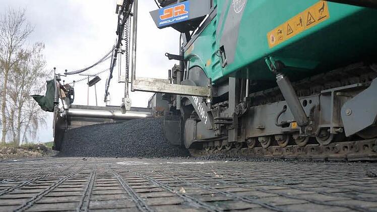 Das dünne Vlies aus Glasfaser soll die Fahrbahn stabilisieren. Foto: Roland Daum