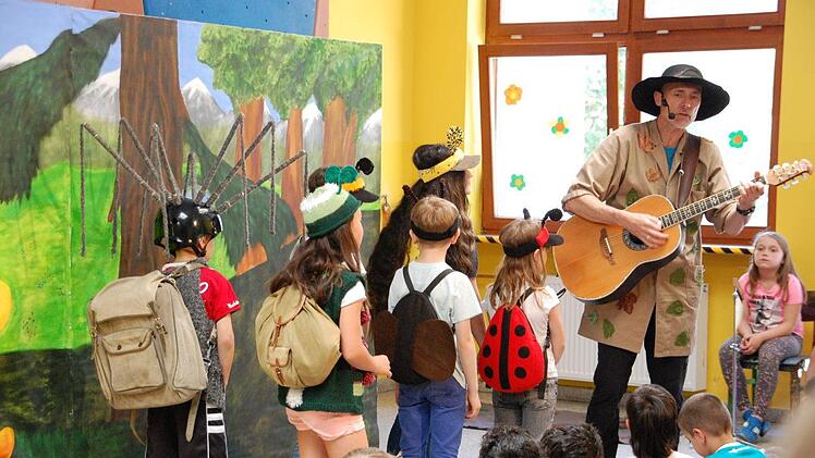 Die Klasse der Insektenschule ist bereit für den Wandertag. Toni Tanner singt Mutmachlieder und fordert zu Selbstbewusstsein auf.