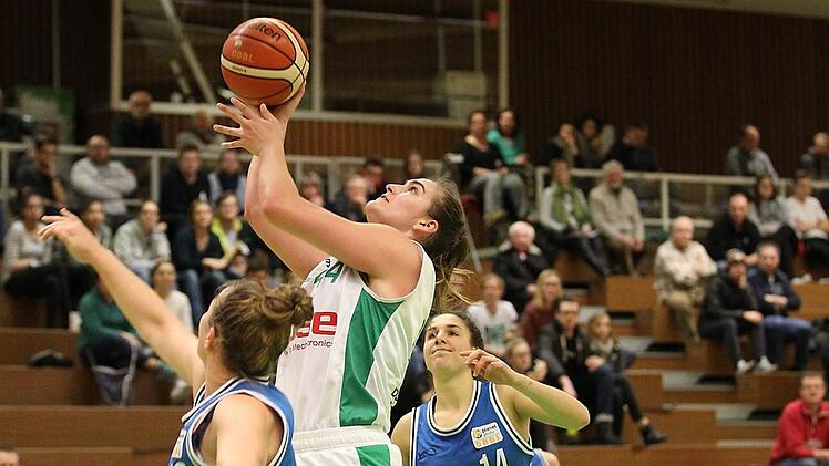 Die Bamberger Centerin Victoria Waldner punktet, der Würzburger Neuzugang Kate Gaze (l.) hat das Nachsehen; hinten die Gäste-Spielerin Jenna Bugiardini. Foto: sportpress