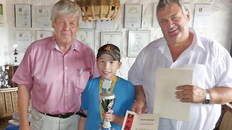 Stolz hält Justin Quindt den Siegespokal der 37. Schülerolympiade des TSV Himmelkron in Händen. Mit im Bild Organisator Erwin Tischer (links) und Bürgermeister Gerhard Schneider (rechts). Foto: Klaus-Peter Wulf