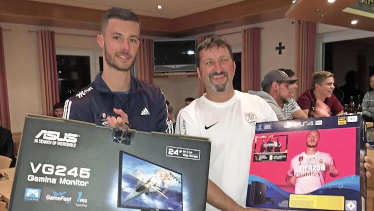 Lukas "Badeschlappen" H&ouml;sch (links) &uuml;bergab im Rahmen einer Fifa-20-Team-Night als Content Creator des BFV das E-Football-Komplettpaket an Klaus Beranek (rechts) vom TSV Neukenroth, der f&uuml;r den Verein am Gewinnspiel des BFV teilgenommen hatte.  Fotos: pr
