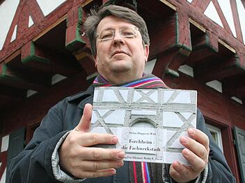 Stefan Huppertz-Wild mit seinem Bildband vor dem Frechshaus Foto: Oswald