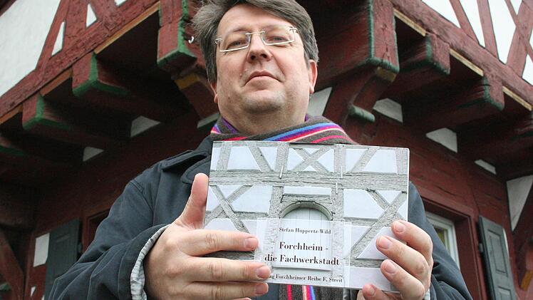 Stefan Huppertz-Wild mit seinem Bildband vor dem Frechshaus Foto: Oswald