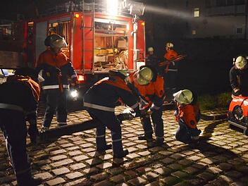 Die Jugendfeuerwehren kuppeln in Wallenels die Saugleitung, schließen sie an die Pumpe an und holen damit das Löschwasser aus der "Wilden Rodach". Fotos: Florian Weiß/Hans Stumpf