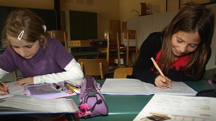 Laura und Hanna machen Hausaufgaben.