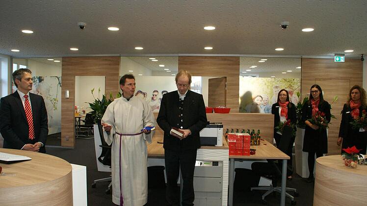 Nach einem umfassenden Umbau eröffnete gestern die Knetzgauer Sparkassen-Filiale wieder ihre Türen. Den kirchlichen Segen spendeten Pastoralreferent Volker Krieger und Pfarrer Hans-Christian Neiber, beobachtet vom Vorstandsvorsitzenden der Sparkasse Ostunterfranken Peter Schleich (links) und den Kundenberaterinnen Irene Leis, Katharina Kraus und Kathrin Pfennig. Fotos: Sabine Weinbeer