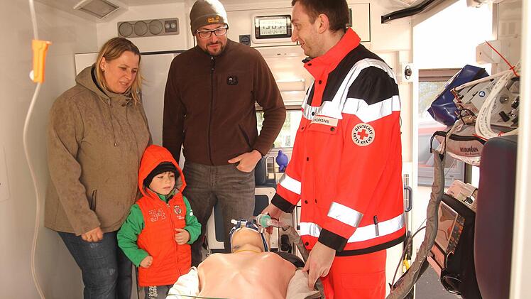 Ein Rettungssanitäter des BRK gibt der Familie hier bereitwillig Informationen über den Einsatz und die Geräte mit dem Rettungswagen.
