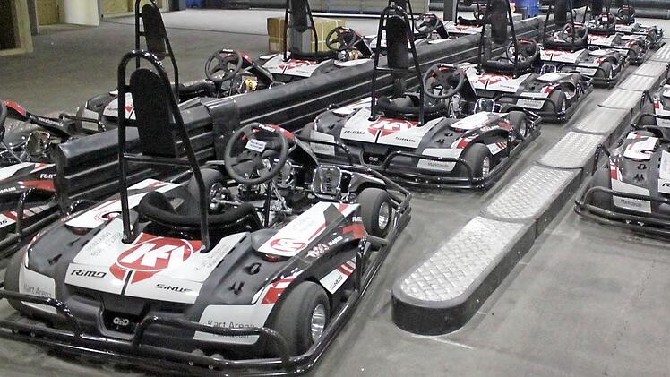 Die nagelneuen Elektro-Karts stehen bereit (unteres Bild), um auf die Piste der Action-Arena (oben) gelenkt zu werden. Fotos: Matthias Einwag