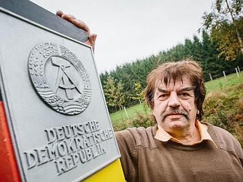 Berthold Schwämmlein posiert neben dem Nachbau einer Grenzsäule aus seinem Privatbestand. Sie waren Markierungen der Staatsgrenze der DDR und wurden erstmals im Herbst 1967 an der innerdeutschen Grenze aufgestellt. Foto: Hendrik Steffens