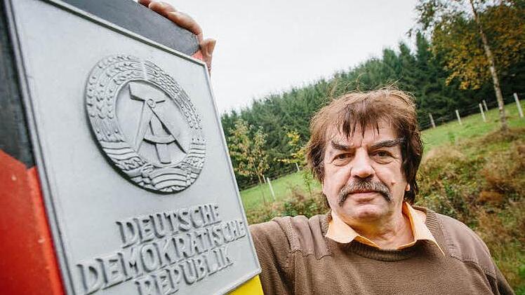 Berthold Schwämmlein posiert neben dem Nachbau einer Grenzsäule aus seinem Privatbestand. Sie waren Markierungen der Staatsgrenze der DDR und wurden erstmals im Herbst 1967 an der innerdeutschen Grenze aufgestellt. Foto: Hendrik Steffens