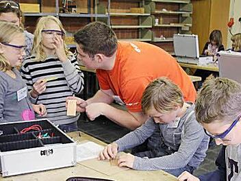 Philipp und Julius (rechts) sind ihre Aufgabe vertieft, während sich  Friederike (links) bei Patrick Ollraum  Rat holt.