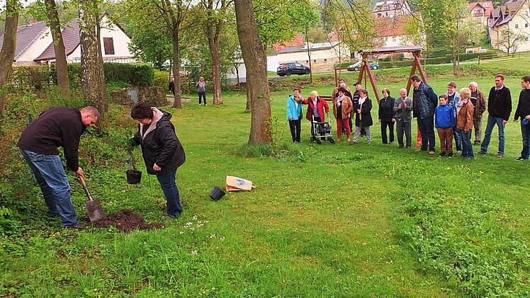Walter Welsch und Silvia Jäger pflanzten den Hollerstrauch auf dem Vorbacher Spielplatz ein. Dabei beobachteten natürlich alle, ob sie es denn auch richtig machen. Foto: privat