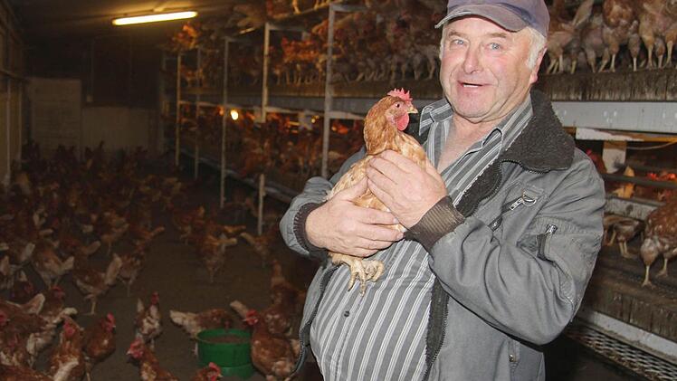 Er hat kein Problem damit, sich mit seinen Hennen im Stall fotografieren zu lassen: Der Poppenholzer Bio-Landwirt Fritz Rösch achtet auf das Tierwohl. Foto: Sonja Adam