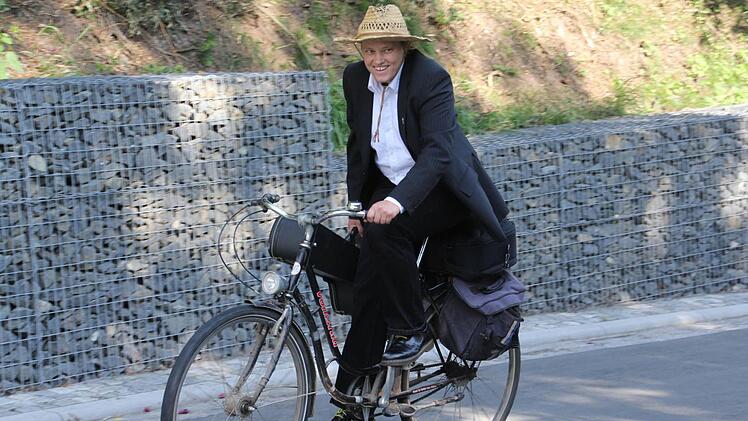Die Gabionenwand, vor der Pfarrerin Sonja von Aschen gut gelaunt zur Eröffnung der Kreisstraße radelt, wurde verhalten kritisiert. Eine gemauerte Steinwand böte ein schöneres Bild, war eine Meinung. Foto: Helmut Will