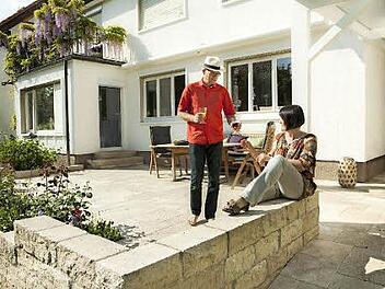 Grund zum Anstoßen: Mauern und Böden aus Naturstein sowie mediterrane Pflanzen wie etwa wilde Rosen holen das Mittelmeer-Feeling in den heimischen Garten. Foto: jonastone