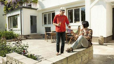 Grund zum Anstoßen: Mauern und Böden aus Naturstein sowie mediterrane Pflanzen wie etwa wilde Rosen holen das Mittelmeer-Feeling in den heimischen Garten. Foto: jonastone
