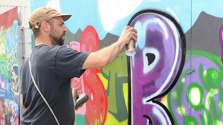 Künstler Philipp Katzenberger bei den Feinarbeiten  für das Kindergarten-Graffiti. Foto: Julia Raab